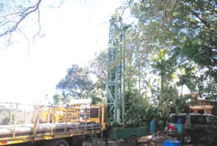 Maquinaria realizando perforación de pozo en zona boscosa